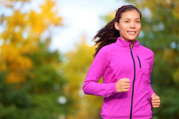 Running woman jogging in autumn forest in fall