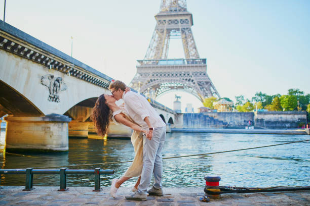 Happy romantic couple in Paris, near the Eiffel tower Happy romantic couple in Paris, near the Eiffel tower. Tourists spending their vacation in France paris france eiffel tower love kissing stock pictures, royalty-free photos & images