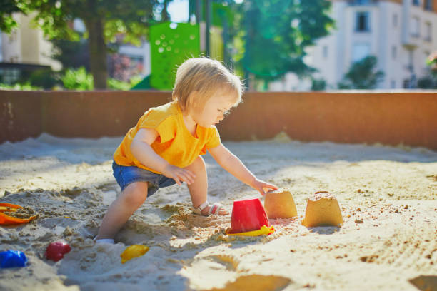 istock little girl having fun on playground in sandpit 1171800930