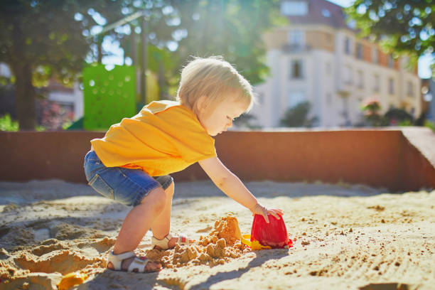 istock little girl having fun on playground in sandpit 1171800933