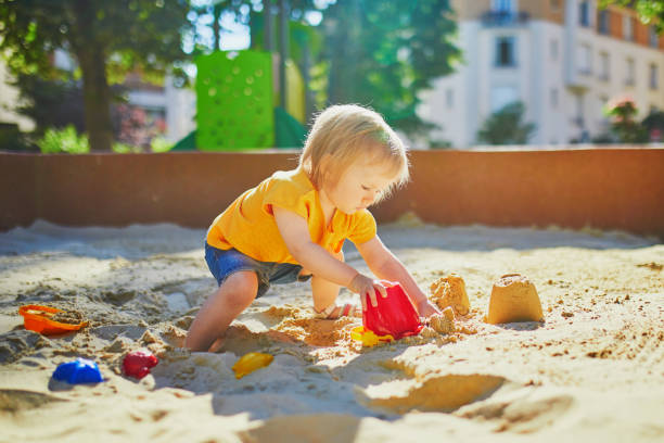 istock little girl having fun on playground in sandpit 1171800946