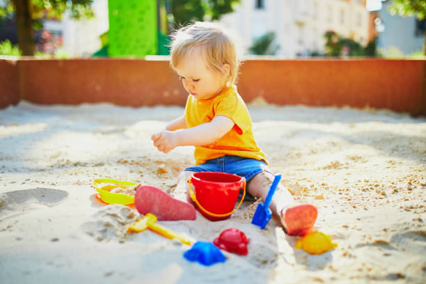 istock little girl having fun on playground in sandpit 1171800968