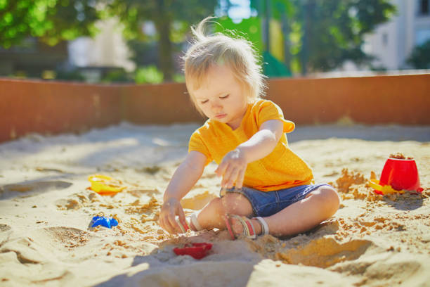istock little girl having fun on playground in sandpit 1171800971