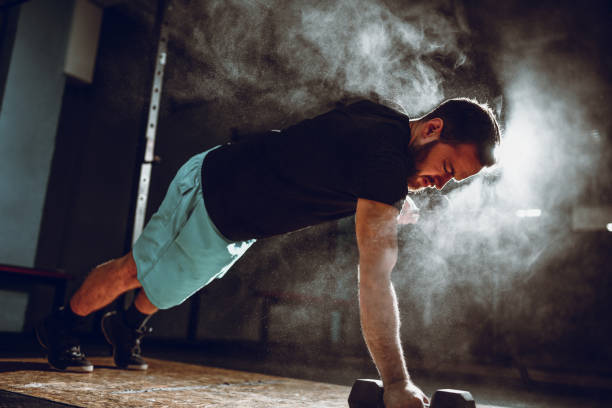 istock Male Athlete Doing Pushups With Dumbbell 1171802620