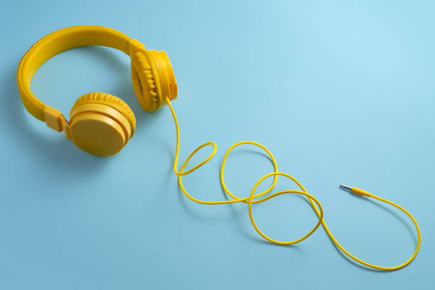 Yellow headphones on blue background. Music concept.