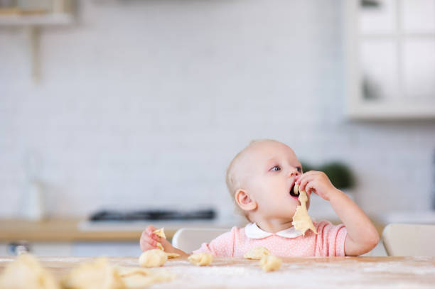 istock little girl pulls a piece of dough in her mouth 1171805854