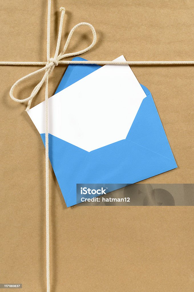 Brown paper parcel with blue envelope Brown paper parcel with blue envelope and blank message card.  Alternative version shown below: Angle Stock Photo