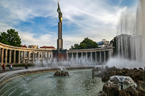 Vienna, Austria - August 28, 2019: Soviet War Memorial known as the Heroes Monument of the Red Army and fountain on Schwarzenbergplatz. It is a white marble colonnade of figure of a Red Army Soldiers.