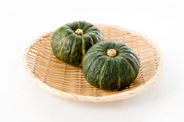 istock Japanese green pumpkin on bamboo colander on white background 1171811771