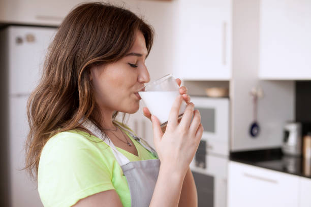 joven bebiendo leche - mujer bebiendo leche fotografías e imágenes de stock