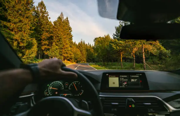 hands of car driver on steering wheel, road trip, driving on highway road