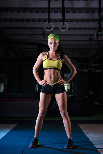 istock beautiful, strong, slender, in good physical shape in the gym doing exercises. Dressed in short shorts and tank top green, on the head bandage. 1171814500