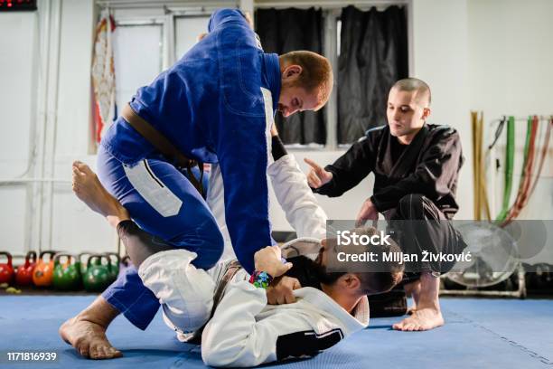 Brazilian Jiu Jitsu Bjj Private Class Professor Of The Martial Arts Academy Working On The Technique Details With His Students Black And Brown Belts Training Open Guard In Kimono Gi Stock Photo - Download Image Now