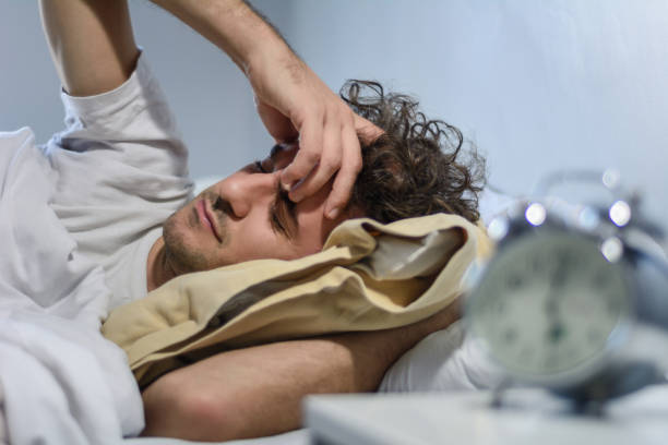 istock Young latin man sleeping with alarm clock. 1171820499