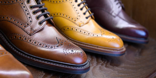 men footwear boutique store Brown full grain leather shoes on wooden display in men shoes boutique store. brogue photos stock pictures, royalty-free photos & images