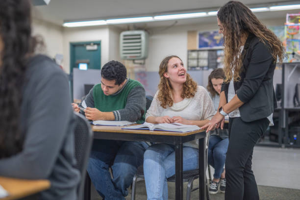 istock Ethnic high school teacher walks around her classroom to check on students' progress 1171825934
