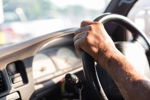 istock Men's hand holding the steering wheel with sunlight 1171830159