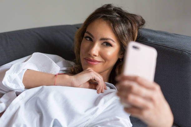 istock Attractive young woman taking a selfie on the bed 1171830463