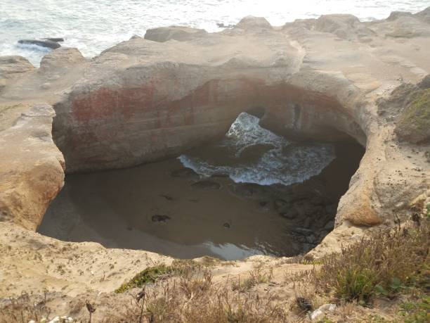 istock large hole in cliff at Oregon coast with ocean and waves 1171835010