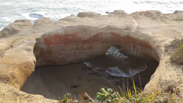 istock large hole in cliff at Oregon coast with ocean and waves 1171835043
