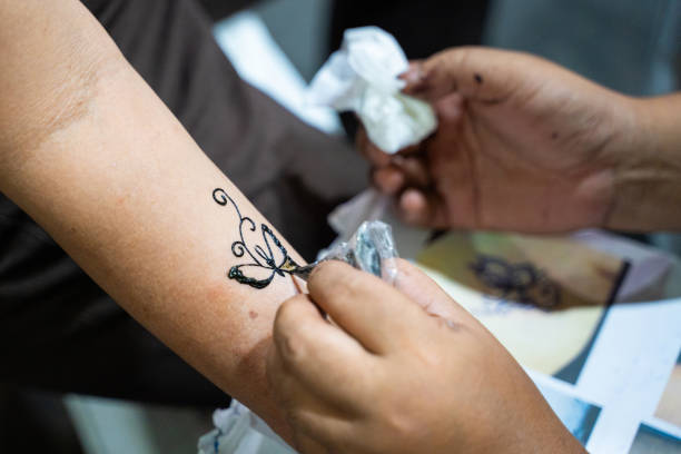 istock artist drawing butterfly on arm Henna paint 1171838565