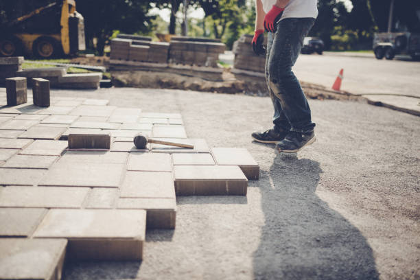 Young man installing paving stones for a new driveway stock photo