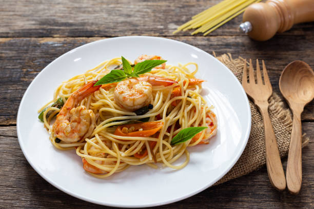 istock Spaghetti with spicy fried shrimp on a wooden table 1171843052