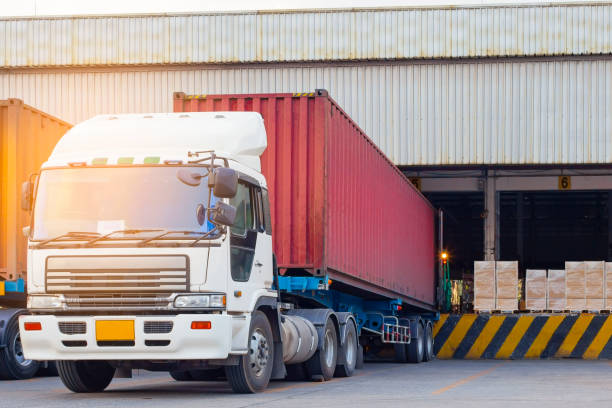 istock Freight transportation and warehouse logistics, trucks trailer docking at warehouse, cargo pallets shipment for loading into a truck 1171845340