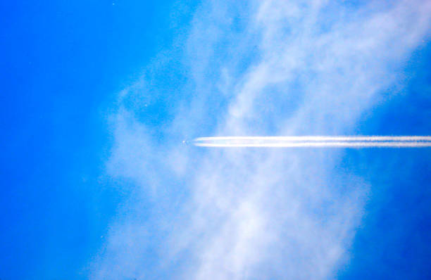 airplane and airplane trail in the blue sky with clouds