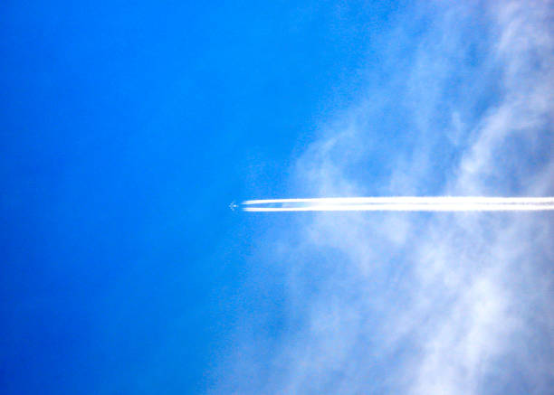 istock airplane and airplane trail in the blue sky with clouds 1171850676