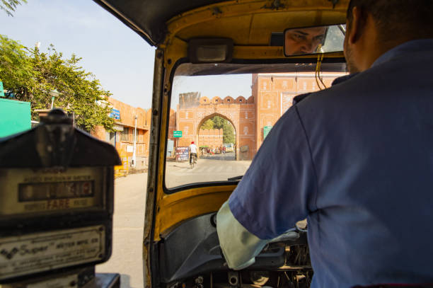 um riquixá (também conhecido como tuc tuc) motorista está dirigindo nas ruas de jaipur, rajasthan, na índia. jaipur é a capital e a maior cidade do estado indiano de rajasthan, na índia. - accident taxi driving tourist - fotografias e filmes do acervo