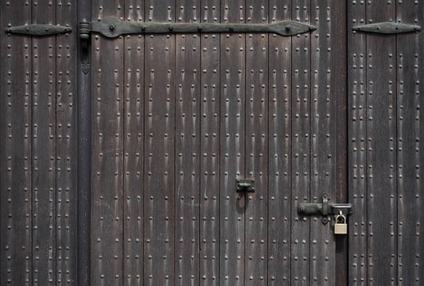 istock Dark gray wooden door and padlock 1171861813