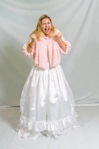 Screaming blonde fourteen year old in ballroom gown and jacket