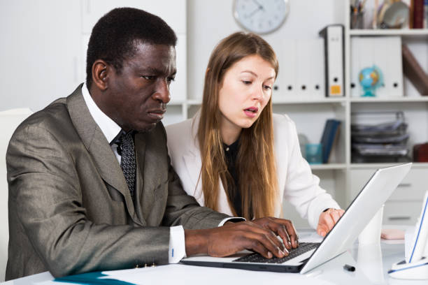 istock Man and woman managers  with laptop working and discussing 1171875727