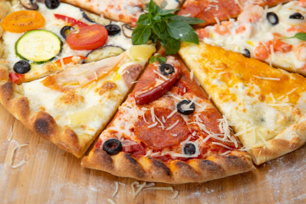 istock Assorted pieces of pizza closeup with different ingredients decorated with Basil 1171878482