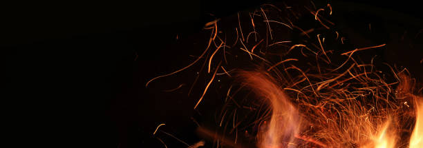 istock Fire, flame on a black background, burning coals and sparks from the fire, motion blur. Abstract background. Banner 1171880624