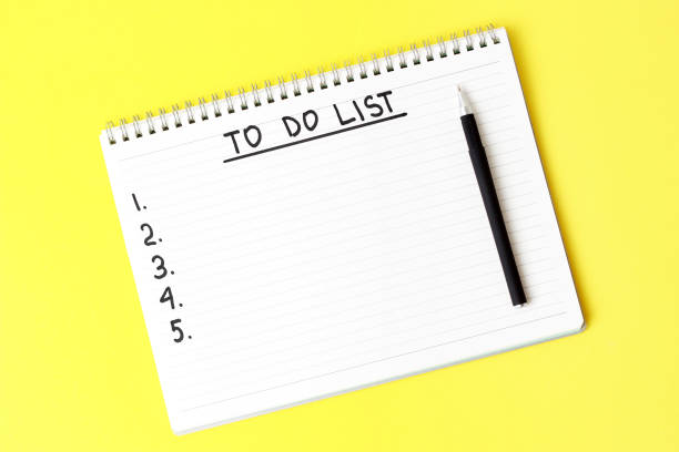 istock To Do List notepad and black pen on yellow background, copy space 1171885102