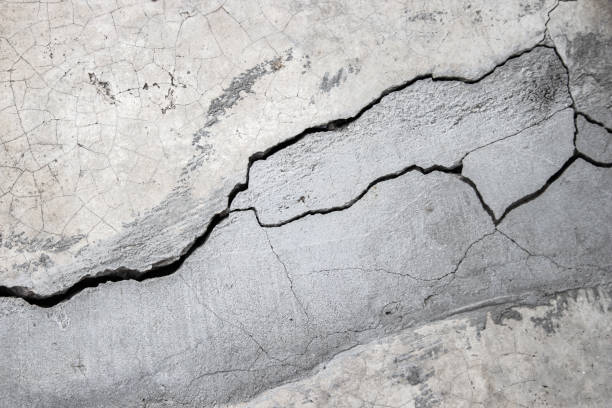 istock Grunge concrete wall at covered with gray cement old surface with crack in industrial building, great for your design and texture background. Black and white cracked floor texture vintage. 1171885128