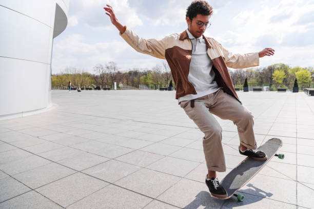 istock Afro skateboarder does ollie in front of building 1171885202