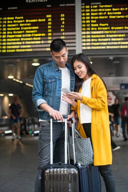 istock Couple navigating on the mobile phone at the Antwerp Central train station 1171886425