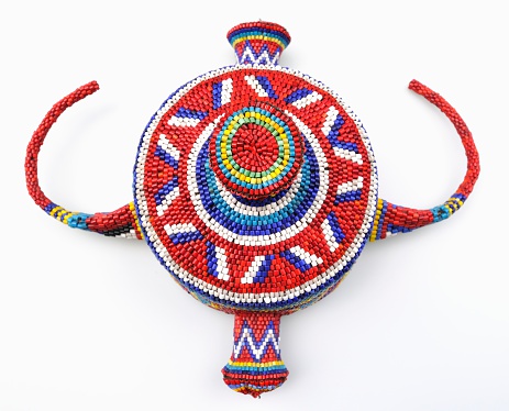 Traditional Congolese headdress with glass beads on white background.