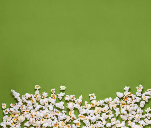 istock White tasty popcorn on a green background. Popcorn pattern on green background. Top view. Copyspace for your text. 1171893041
