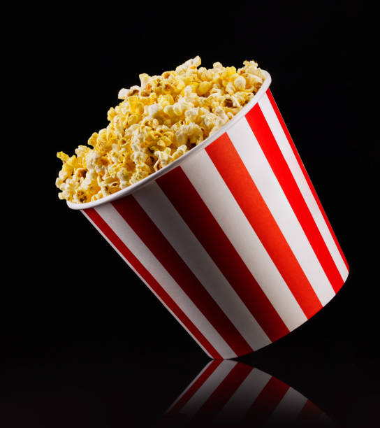 istock Paper striped bucket with popcorn isolated on black background 1171893476