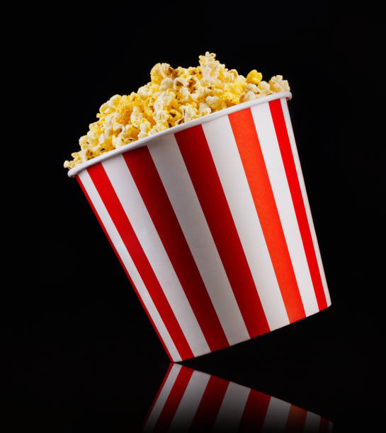 istock Paper striped bucket with popcorn isolated on black background 1171893503