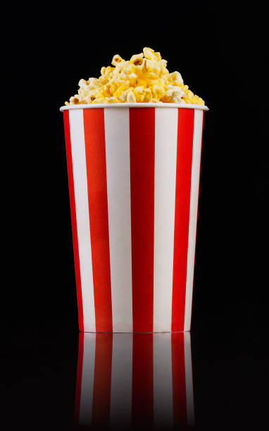 istock Paper striped bucket with popcorn isolated on black background 1171893514