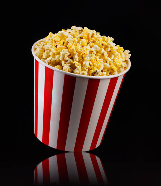istock Paper striped bucket with popcorn isolated on black background 1171893533