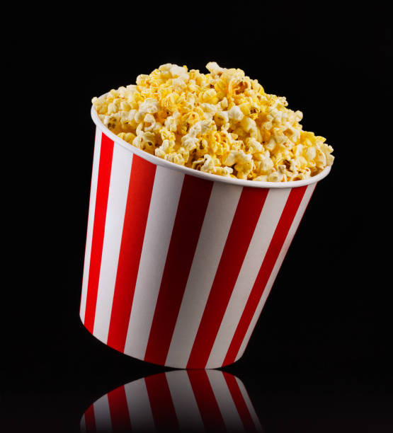 istock Paper striped bucket with popcorn isolated on black background 1171893556