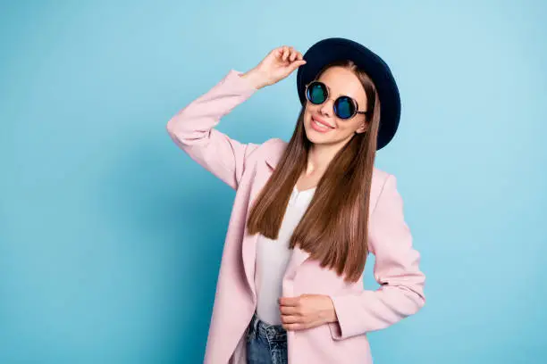 Photo of Portrait of satisfied charming lady touching her fashionable hat have stroll with her best friends wear topcoat isolated over blue color background