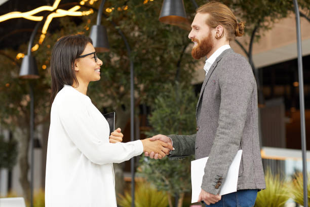 istock Business partners shaking hands outdoors 1171896377