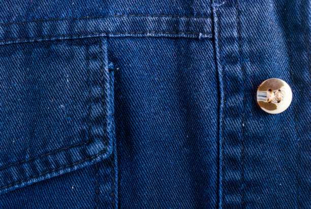 istock clothing items stonewashed cotton fabric texture with seams, clasps, buttons and rivets, macro 1171898840